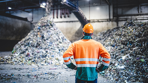 Person standing looking at recycling piles