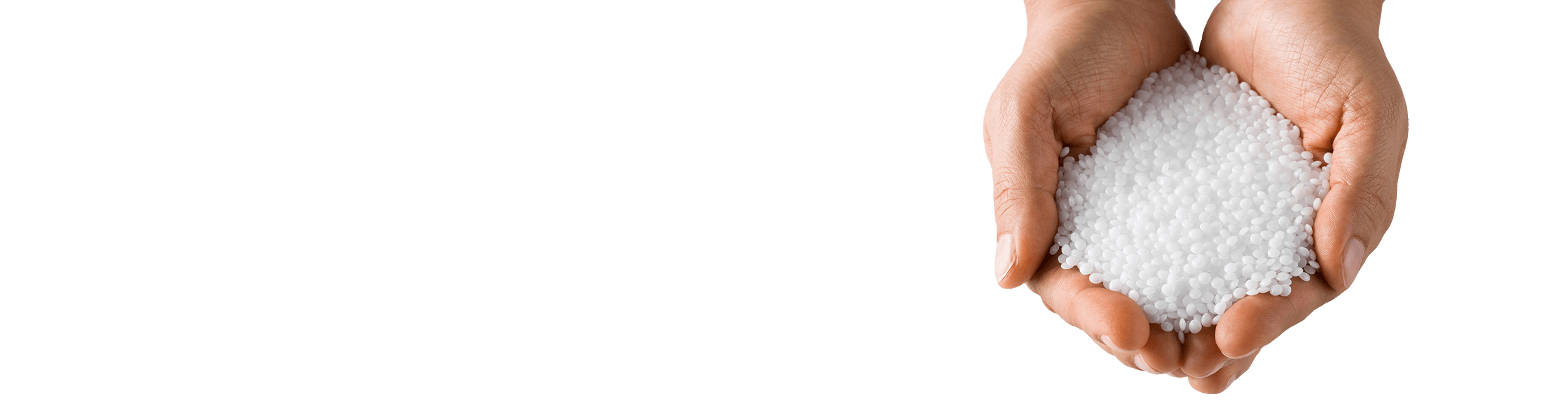 A hand holding polymer particles in the foreground